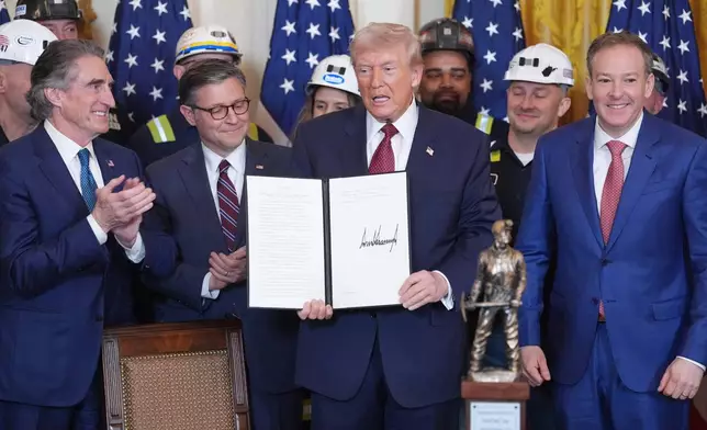 FILE - President Donald Trump holds an executive order regarding coal during an event in the East Room of the White House, Wednesday, Feb. 11, 2026, in Washington, as Interior Secretary Doug Burgum, House Speaker Mike Johnson of La., Environmental Protection Agency director Lee Zeldin and coal miners watch. (AP Photo/Evan Vucci, file)