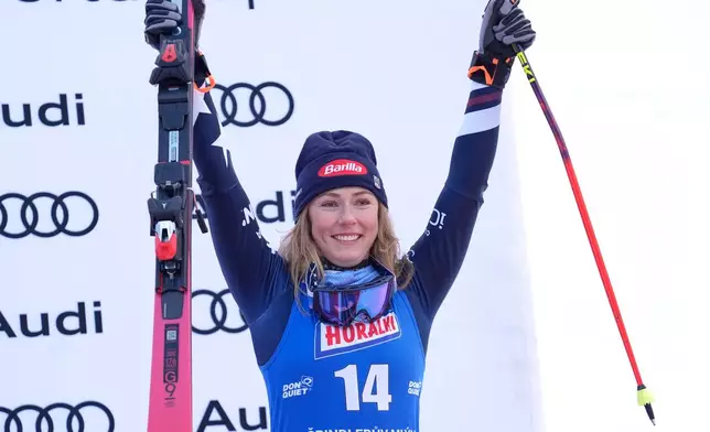 United States' Mikaela Shiffrin celebrates on podium after finishing third in a women's alpine ski, World Cup giant slalom, in Spindleruv Mlyn, Czech Republic, Saturday, Jan. 24, 2026. (AP Photo/Giovanni Auletta)