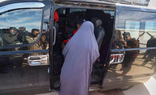 Family members of suspected Islamic State militants who are Australian nationals board a van heading to the airport in Damascus during the first repatriation operation of the year, at Roj Camp in eastern Syria, Monday, Feb. 16, 2026. Thirty-four Australian citizens from 11 families departed the camp. (AP Photo/Baderkhan Ahmad)