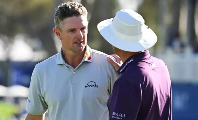 Justin Rose, of England, left, talks to Joel Dahmen on the 18th green after winning the Farmers Insurance Open golf tournament Sunday, Feb. 1, 2026, at Torrey Pines in San Diego. (AP Photo/Denis Poroy)