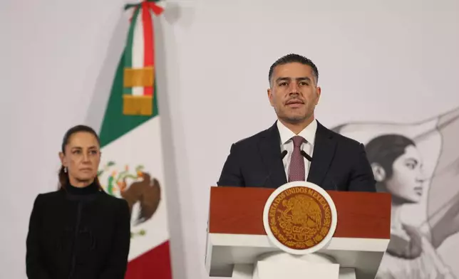 Mexican Security and Citizen Protection Minister Omar Garcia Harfuch speaks as President Claudia Sheinbaum looks on during her daily, morning news conference at the National Palace in Mexico City, Monday, Feb. 23, 2026, the day after the Mexican army killed Jalisco New Generation Cartel leader Nemesio Oseguera, known as "El Mencho." (AP Photo/Ginnette Riquelme)