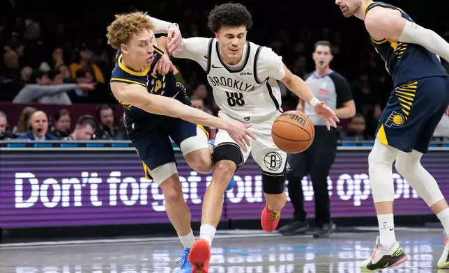 Brooklyn Nets guard Nolan Traore (88) fights for control of the ball with Indiana Pacers guard Taelon Peter during the second half of an NBA basketball game, Wednesday, Feb. 11, 2026, in New York. (AP Photo/Yuki Iwamura)