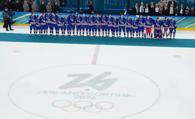 United States players and coaches stand during the playing of the national anthem after winning the women's ice hockey gold medal game at the 2026 Winter Olympics, in Milan, Italy, Thursday, Feb. 19, 2026. (AP Photo/Carolyn Kaster)