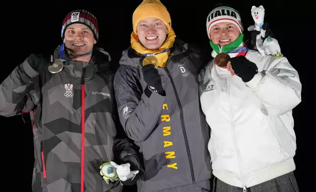From left, second placed Austria's Jonas Mueller, first placed Germany's Max Langenhan and third placed Italy's Dominik Fischnaller pose with their medals after the men's single luge competition at the 2026 Winter Olympics, in Cortina d'Ampezzo, Italy, Sunday, Feb. 8, 2026. (AP Photo/Alessandra Tarantino)
