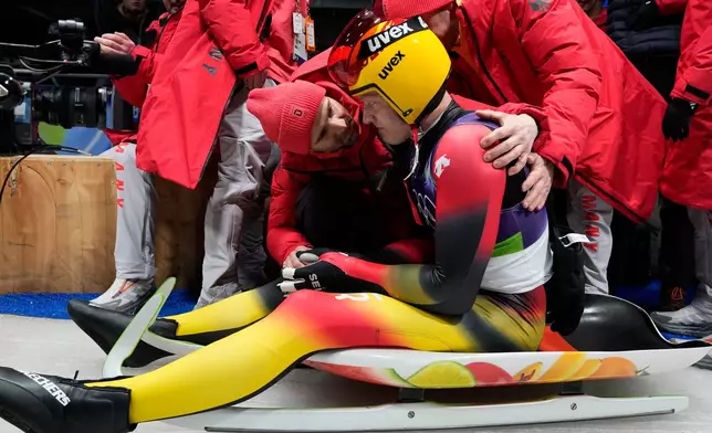 Germany's Max Langenhan reacts after winning the gold medal as he arrives at the finish during a men's single luge run at the 2026 Winter Olympics, in Cortina d'Ampezzo, Italy, Sunday, Feb. 8, 2026. (AP Photo/Alessandra Tarantino)