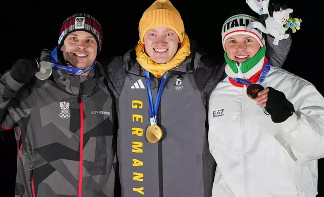 From left, second placed Austria's Jonas Mueller, first placed Germany's Max Langenhan and third placed Italy's Dominik Fischnaller pose with their medals after the men's single luge competition at the 2026 Winter Olympics, in Cortina d'Ampezzo, Italy, Sunday, Feb. 8, 2026. (AP Photo/Alessandra Tarantino)