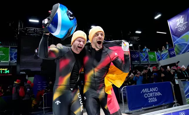 Germany's gold medalists Johannes Lochner, left, and Georg Fleischhauer celebrate at the finish after the two man bobsled competition at the 2026 Winter Olympics, in Cortina d'Ampezzo, Italy, Tuesday, Feb. 17, 2026. (AP Photo/Alessandra Tarantino)