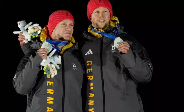 Germany's silver medalists Francesco Friedrich, left, and Alexander Schuller, right, pose with their medals after the two man bobsled competition at the 2026 Winter Olympics, in Cortina d'Ampezzo, Italy, Tuesday, Feb. 17, 2026. (AP Photo/Alessandra Tarantino)