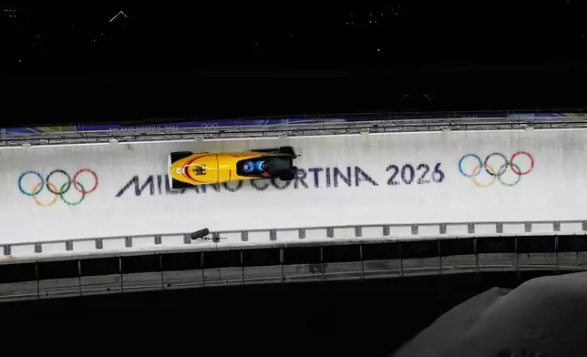 Germany's Johannes Lochner and Georg Fleischhauer slide down the track during a two man bobsled run at the 2026 Winter Olympics, in Cortina d'Ampezzo, Italy, Tuesday, Feb. 17, 2026. (AP Photo/Alessandra Tarantino)
