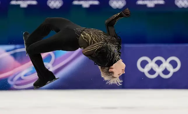 Ilia Malinin of the United States does a back flip while competing during the men's free skate program in figure skating at the 2026 Winter Olympics, in Milan, Italy, Friday, Feb. 13, 2026. (AP Photo/Ashley Landis)