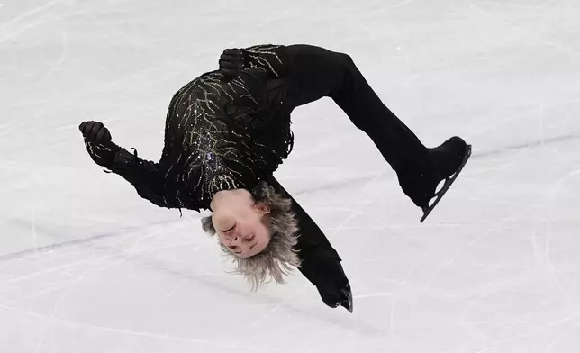 Ilia Malinin of the United States does a back flip while competing during the men's free skate program in figure skating at the 2026 Winter Olympics, in Milan, Italy, Friday, Feb. 13, 2026. (AP Photo/Stephanie Scarbrough)