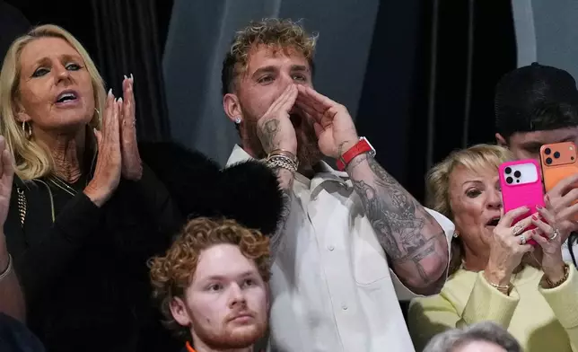 Jake Paul of the U.S. screams as his fiancée Jutta Leerdam of the Netherlands celebrates with her silver medal on the podium of the women's 500 meters speedskating race at the 2026 Winter Olympics, in Milan, Italy, Sunday, Feb. 15, 2026. (AP Photo/Antonio Calanni)