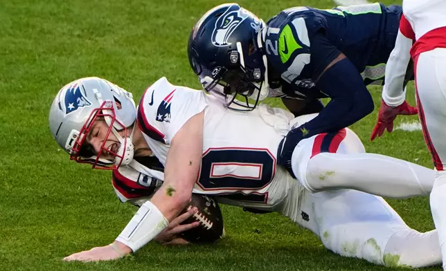 New England Patriots quarterback Drake Maye (10) is sacked by Seattle Seahawks cornerback Devon Witherspoon (21) during the first half of the NFL Super Bowl 60 football game, Sunday, Feb. 8, 2026, in Santa Clara, Calif. (AP Photo/Charlie Riedel)