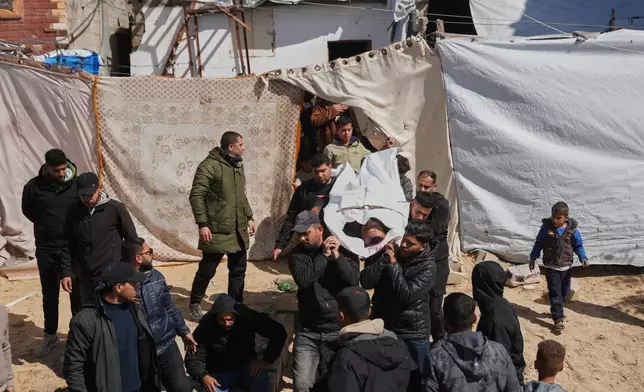 Mourners carry the body of the Palestinian policeman, Khaled Al-Zayan, who was killed in an Israeli military strike, during his funeral in Khan Younis, southern Gaza Strip, Friday, Feb. 27, 2026. (AP Photo/Abdel Kareem Hana)