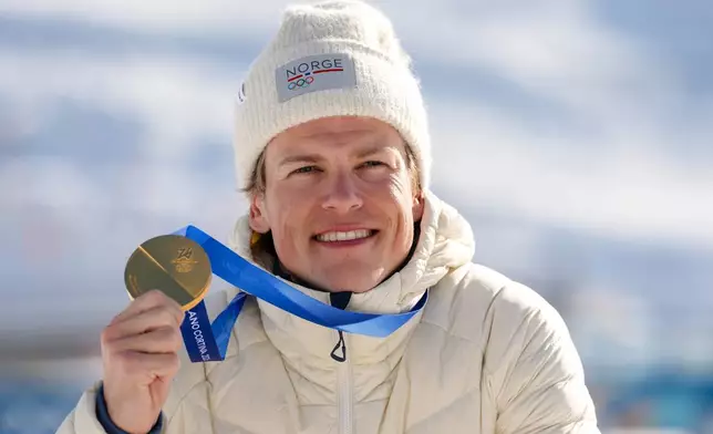 Johannes Hoesflot Klaebo, of Norway, poses after winning the gold medal in the cross country skiing men's 10km + 10km skiathlon at the 2026 Winter Olympics, in Tesero, Italy, Sunday, Feb. 8, 2026. (AP Photo/Kirsty Wigglesworth)