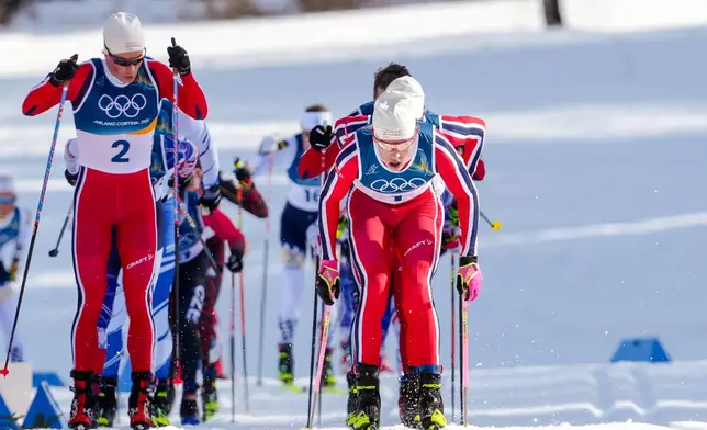 Johannes Hoesflot Klaebo, of Norway, and Harald Oestberg Amundsen, also of Norway, left, compete in during the cross country skiing men's 10km + 10km skiathlon at the 2026 Winter Olympics, in Tesero, Italy, Sunday, Feb. 8, 2026. (AP Photo/Evgeniy Maloletka)