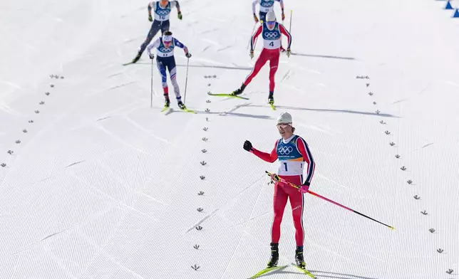 Johannes Hoesflot Klaebo, of Norway, approaches the finish line to win the gold medal in the cross country skiing men's 10km + 10km skiathlon at the 2026 Winter Olympics, in Tesero, Italy, Sunday, Feb. 8, 2026. (AP Photo/Matthias Schrader)
