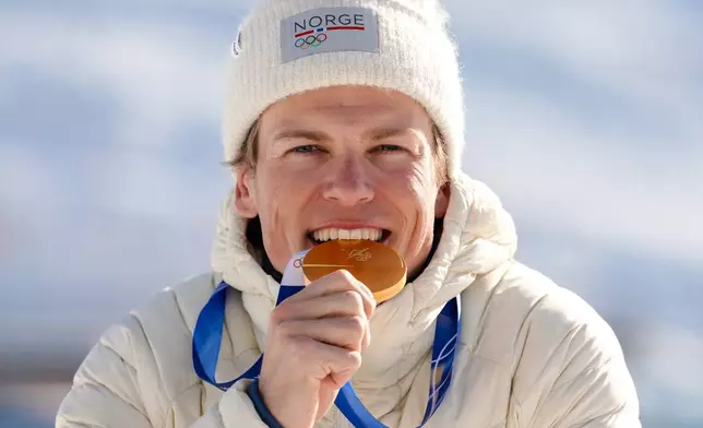 Johannes Hoesflot Klaebo, of Norway, poses after winning the gold medal in the cross country skiing men's 10km + 10km skiathlon at the 2026 Winter Olympics, in Tesero, Italy, Sunday, Feb. 8, 2026. (AP Photo/Kirsty Wigglesworth)