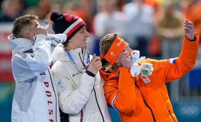 Gold medallist Metodej Jilek of Czechia, center, celebrates on the podium with Vladimir Semirunniy of Poland, left and silver medal, and Jorrit Bergsma of the Netherlands, right and bronze medal, after the men's 10,000 meters speedskating race at the 2026 Winter Olympics, in Milan, Italy, Friday, Feb. 13, 2026. (AP Photo/Luca Bruno)