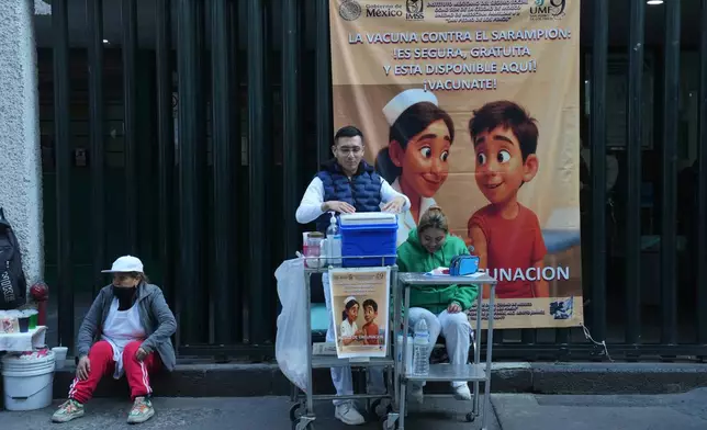 A health worker, center, prepares to administer a dose of the measles vaccine outside a public hospital in Mexico City, Wednesday, Feb. 4, 2026. (AP Photo/Marco Ugarte)