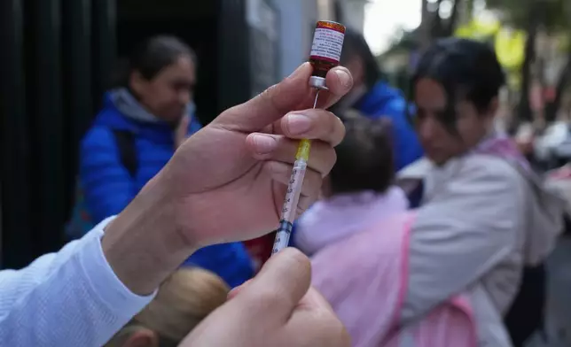 A health worker administers a dose of the measles vaccine outside a public hospital in Mexico City, Wednesday, Feb. 4, 2026. (AP Photo/Marco Ugarte)