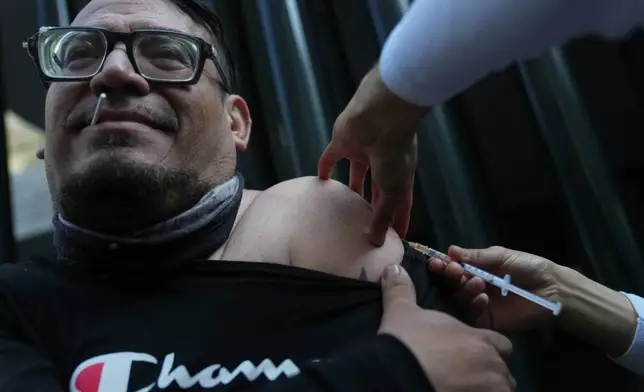 A health worker administers a dose of the measles vaccine outside a public hospital in Mexico City, Wednesday, Feb. 4, 2026. (AP Photo/Marco Ugarte)