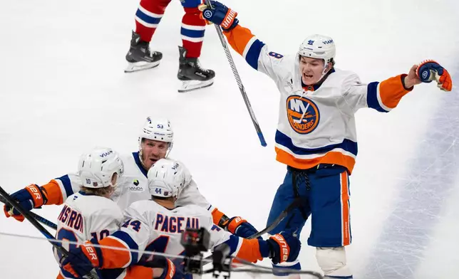 New York Islanders' Jean-Gabriel Pageau (44) celebrates after his winning goal with teammates Simon Holmstrom (10), Casey Cizikas (53) and Matthew Schaefer (48) during overtime NHL hockey game action against the Montreal Canadiens in Montreal, Thursday, Feb. 26, 2026. (Christinne Muschi/The Canadian Press via AP)