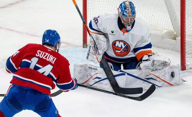 New York Islanders goaltender Ilya Sorokin (30) makes a save against Montreal Canadiens' Nick Suzuki (14) during second-period NHL hockey game action in Montreal, Thursday, Feb. 26, 2026. (Christinne Muschi/The Canadian Press via AP)