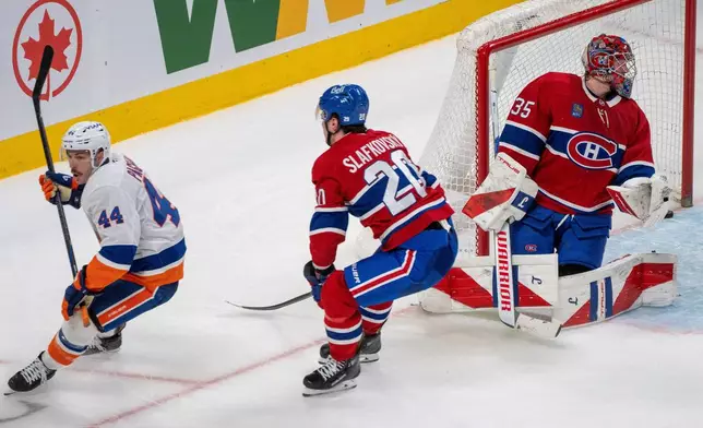 New York Islanders' Jean-Gabriel Pageau (44) beats Montreal Canadiens' Juraj Slafkovsky (20) to score on goaltender Samuel Montembeault (35) during the overtime of an NHL hockey game in Montreal, Thursday, Feb. 26, 2026. (Christinne Muschi/The Canadian Press via AP)