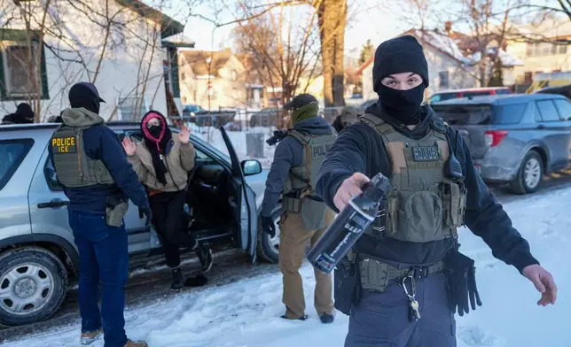 Activists are approached by federal agents for following agent vehicles, on Tuesday, Feb. 3, 2026, in Minneapolis. (AP Photo/Ryan Murphy)