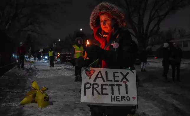 A woman attends a vigil for Alex Pretti who was fatally shot by a federal agent, at the Minneapolis VA Hospital, where Pretti worked, on Sunday, Feb. 1, 2026, in Minneapolis. (AP Photo/Ryan Murphy)