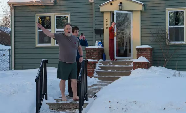 People film and yell at federal agents to leave their neighborhood while agents conduct immigration enforcement operations in a neighborhood on Monday, Feb. 2, 2026, in Minneapolis. (AP Photo/Ryan Murphy)