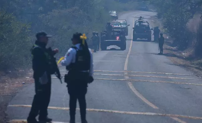 Soldiers stand guard in Cointzio, Michoacán state, Mexico, Sunday, Feb. 22, 2026, after the death of the leader of the Jalisco New Generation Cartel, Nemesio Rubén Oseguera Cervantes, known as "El Mencho." (AP Photo/Armando Solis)