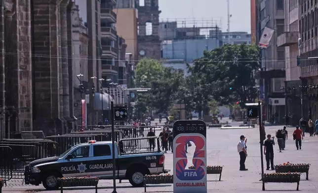 Police officers stand guard in downtown Guadalajara, Jalisco state, Mexico, Sunday, Feb. 22, 2026, after the death of the leader of the Jalisco New Generation Cartel, Nemesio Rubén Oseguera Cervantes, known as "El Mencho." (AP Photo/Alejandra Leyva)