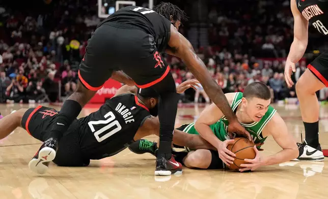 Boston Celtics guard Payton Pritchard (11) tries to get control of the ball against Houston Rockets' Tari Eason (17), and Josh Okogie (20) during the first half of an NBA basketball game, in Houston, Wednesday, Feb. 4, 2026. (AP Photo/ Karen Warren)