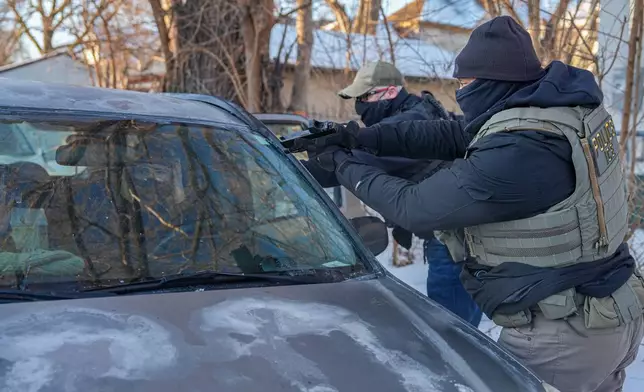 Activists are approached by a federal agent brandishing a firearm, for following agent vehicles, on Tuesday, Feb. 3, 2026, in Minneapolis. (AP Photo/Ryan Murphy)