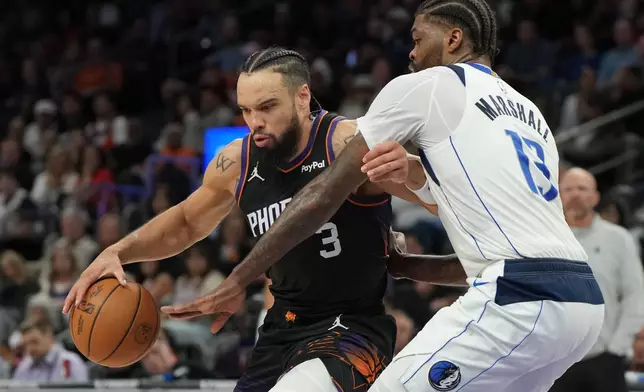 Phoenix Suns forward Dillon Brooks shields the ball from Dallas Mavericks forward Naji Marshall (13) during the second half of an NBA basketball game, Tuesday, Feb. 10, 2026, in Phoenix. (AP Photo/Rick Scuteri)