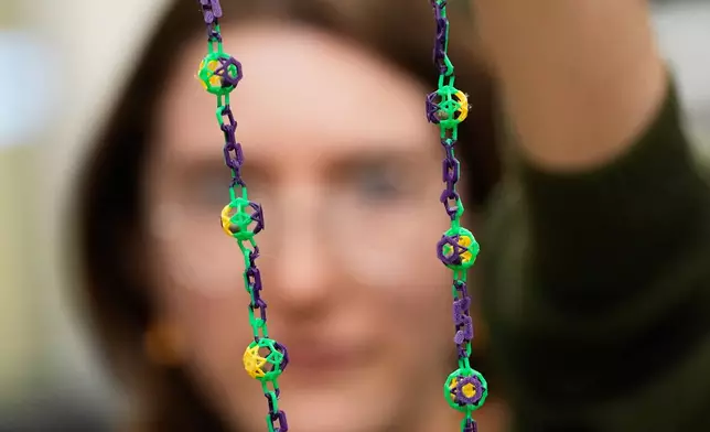 Alexis Strain, graduate student in biological sciences at Louisiana State University, shows the biodegradable Mardi Gras beads they are developing, Jan. 27, 2026, in Baton Rouge, La. (AP Photo/Gerald Herbert)