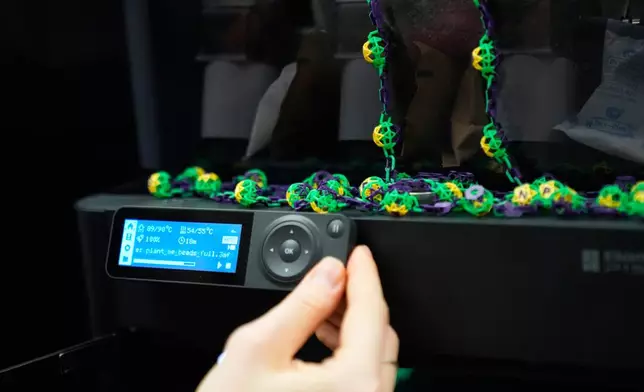 Alexis Strain, graduate student in biological sciences at Louisiana State University shows A 3D printer they are using to create biodegradable Mardi Gras beads, Jan. 27, 2026, in Baton Rouge, La. (AP Photo/Gerald Herbert)