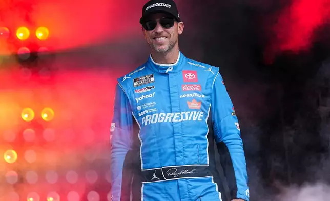 FILE - Denny Hamlin smiles prior to a NASCAR Cup Series auto race at Charlotte Motor Speedway, Oct. 5, 2025, in Concord, N.C. (AP Photo/Matt Kelley, File)