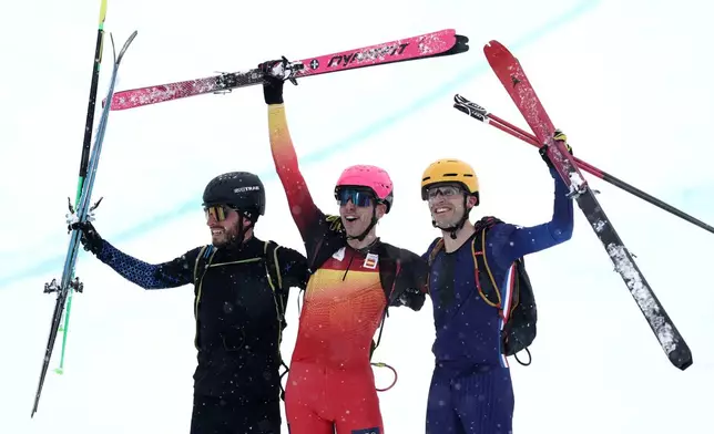 Spain's Oriol Cardona Coll, center, celebrates winning the gold medal in a ski mountaineering men's sprint final, with silver medalist Individual Neutral Athlete Nikita Filippov, left, and bronze medalist France's Thibault Anselmet, at the 2026 Winter Olympics, in Bormio, Italy, Thursday, Feb. 19, 2026. (AP Photo/Gabriele Facciotti)