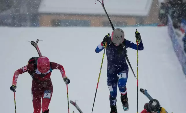 France's Emily Harrop, center, followed by Switzerland's Caroline Ulrich, left, competes during a ski mountaineering women's sprint heat, at the 2026 Winter Olympics, in Bormio, Italy, Thursday, Feb. 19, 2026. (AP Photo/John Locher)