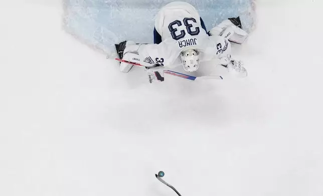 Canada's Macklin Celebrini (17) scores on a penalty shot against France's goalkeeper Julian Junca (33) in the second period during a preliminary round game of men's ice hockey between Canada and France at the 2026 Winter Olympics, in Milan, Italy, Sunday, Feb. 15, 2026. (AP Photo/Carolyn Kaster)