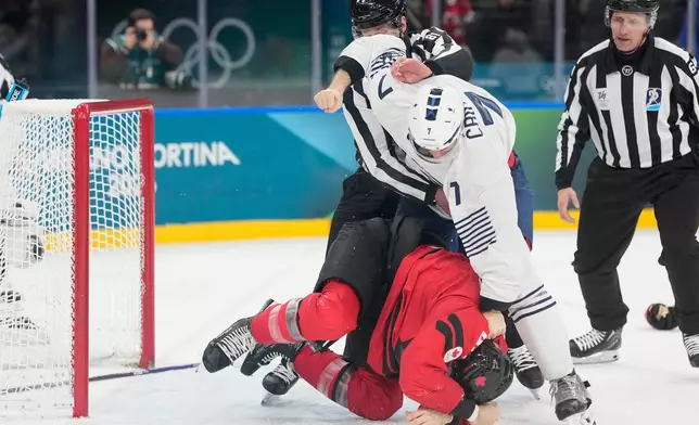 France's Pierre Crinon (7) and Canada's Tom Wilson (43) fight in the third period during a preliminary round game of men's ice hockey between Canada and France at the 2026 Winter Olympics, in Milan, Italy, Sunday, Feb. 15, 2026. (AP Photo/Hassan Ammar)