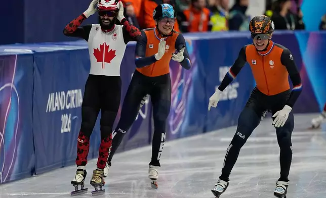 Steven Dubois of Canada wins gold as Melle van 't Wout of the Netherlands wins silver, left, and Jens van 't Wout of the Netherlands wins bronze during the short track speed skating men's 500m at the 2026 Winter Olympics, in Milan, Italy, Wednesday, Feb. 18, 2026. (AP Photo/Ashley Landis)
