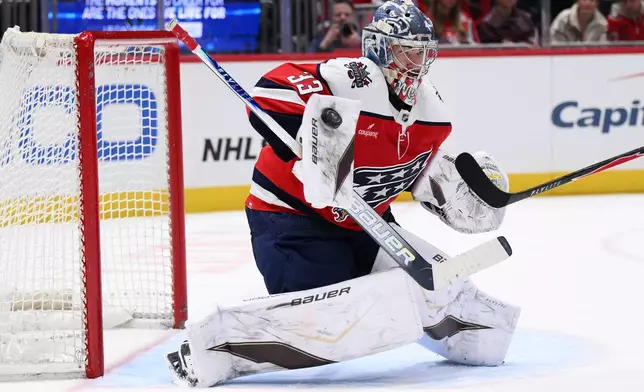 Washington Capitals goaltender Clay Stevenson (33) deflects the puck during the second period of an NHL hockey game against the Carolina Hurricanes, Saturday, Jan. 31, 2026, in Washington. (AP Photo/Nick Wass)