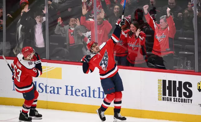 Washington Capitals right wing Justin Sourdif, right, celebrates his game-wining goal next to center Ethen Frank (53) in the overtime of an NHL hockey game against the Carolina Hurricanes, Saturday, Jan. 31, 2026, in Washington. (AP Photo/Nick Wass)