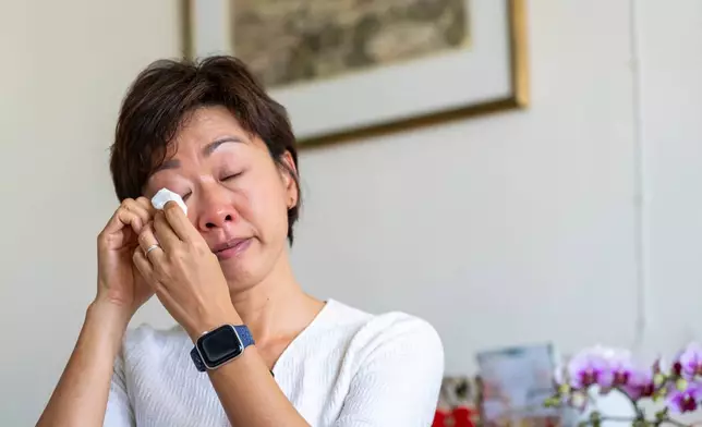 Phyllis Lo, daughter of one of the victims killed by the deadly Wang Fuk Court fire, reacts during an interview at her house in Hong Kong, Friday, Feb. 6, 2026. (AP Photo/Chan Long Hei)