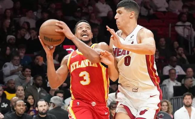 Atlanta Hawks guard CJ McCollum (3) drives to the basket as Miami Heat forward Simone Fontecchio (0) defends during the first half of an NBA basketball game Tuesday, Feb. 3, 2026, in Miami. (AP Photo/Marta Lavandier)