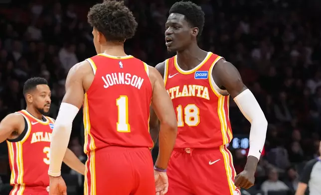 Atlanta Hawks forward Jalen Johnson (1) celebrates with Mouhamed Gueye (18) after dunking the ball during the first half of an NBA basketball game against the Miami Heat Tuesday, Feb. 3, 2026, in Miami. (AP Photo/Marta Lavandier)